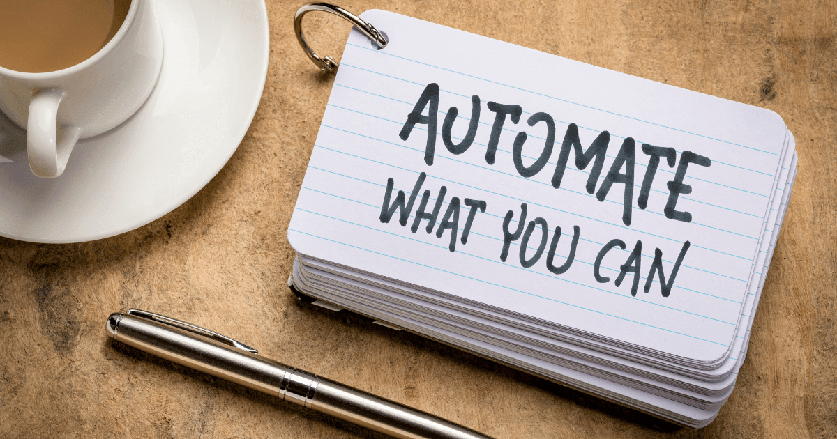 automate what you can written on an index card sitting to the left is a cup of coffee and below the index card is a silver pen